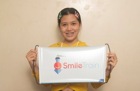 Teen holds Smile Train banner